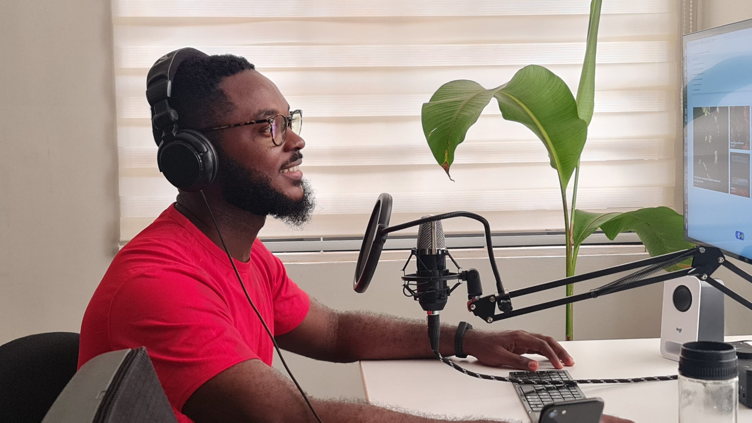 A black male podcaster recording an episode, wearing headphones and speaking into a microphone with passion and confidence.